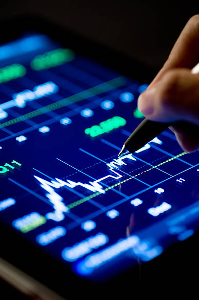 Market Analyze with Digital Moniter focus on tip of the pen.